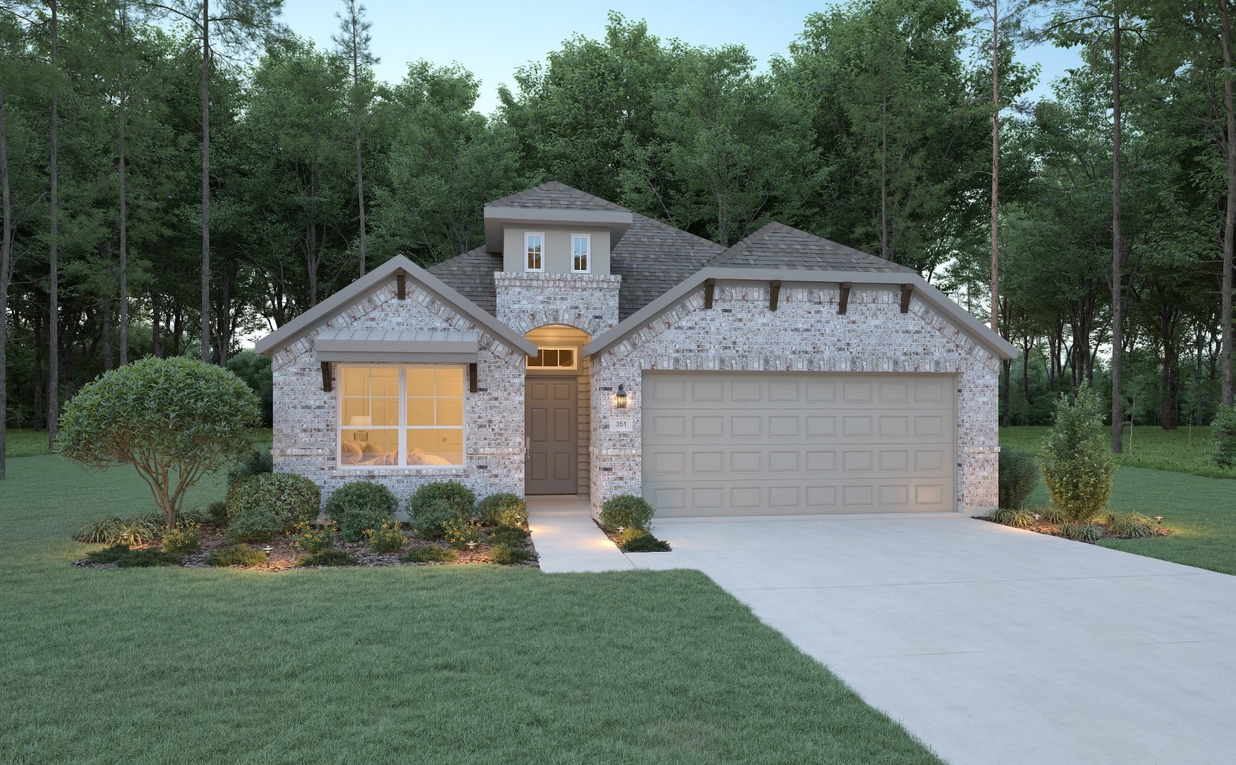 Single-story brick house with a double garage, brown front door, and large front window. Manicured shrubs and trees surround the home, with a concrete driveway and a forested background.