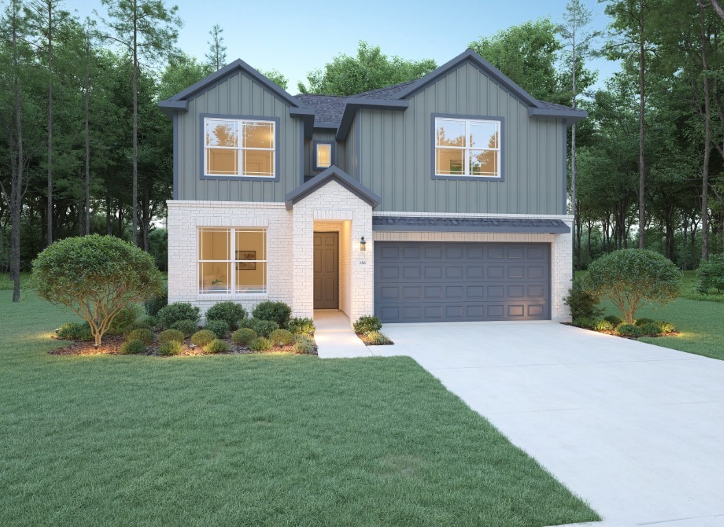 A modern two-story house with gray vertical siding and white brick exterior, a double garage, landscaped front yard, and surrounded by trees. The driveway and walkway lead to a central front door.
