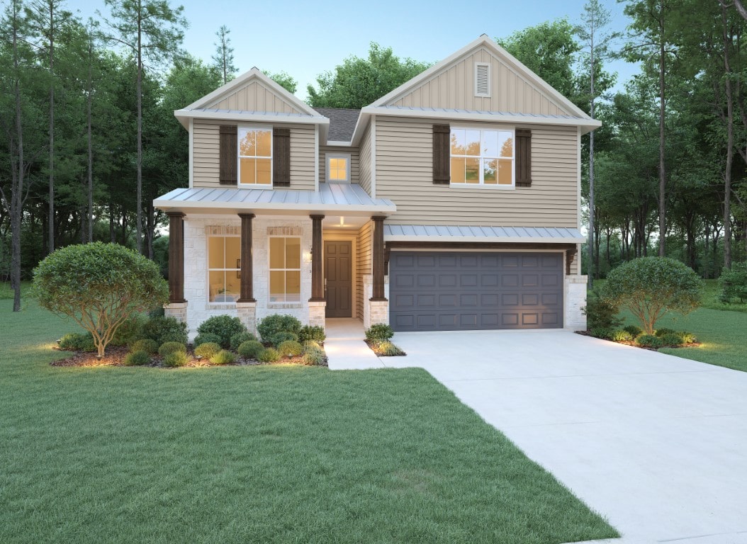 A two-story suburban house with beige siding, brown shutters, a covered front porch with columns, a double garage, and a well-manicured lawn, surrounded by trees.