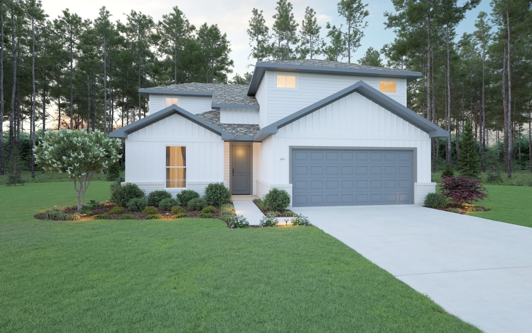 A modern two-story white house with a gray roof and two-car garage sits surrounded by a manicured lawn, landscaped bushes, and tall pine trees in the background at dusk.