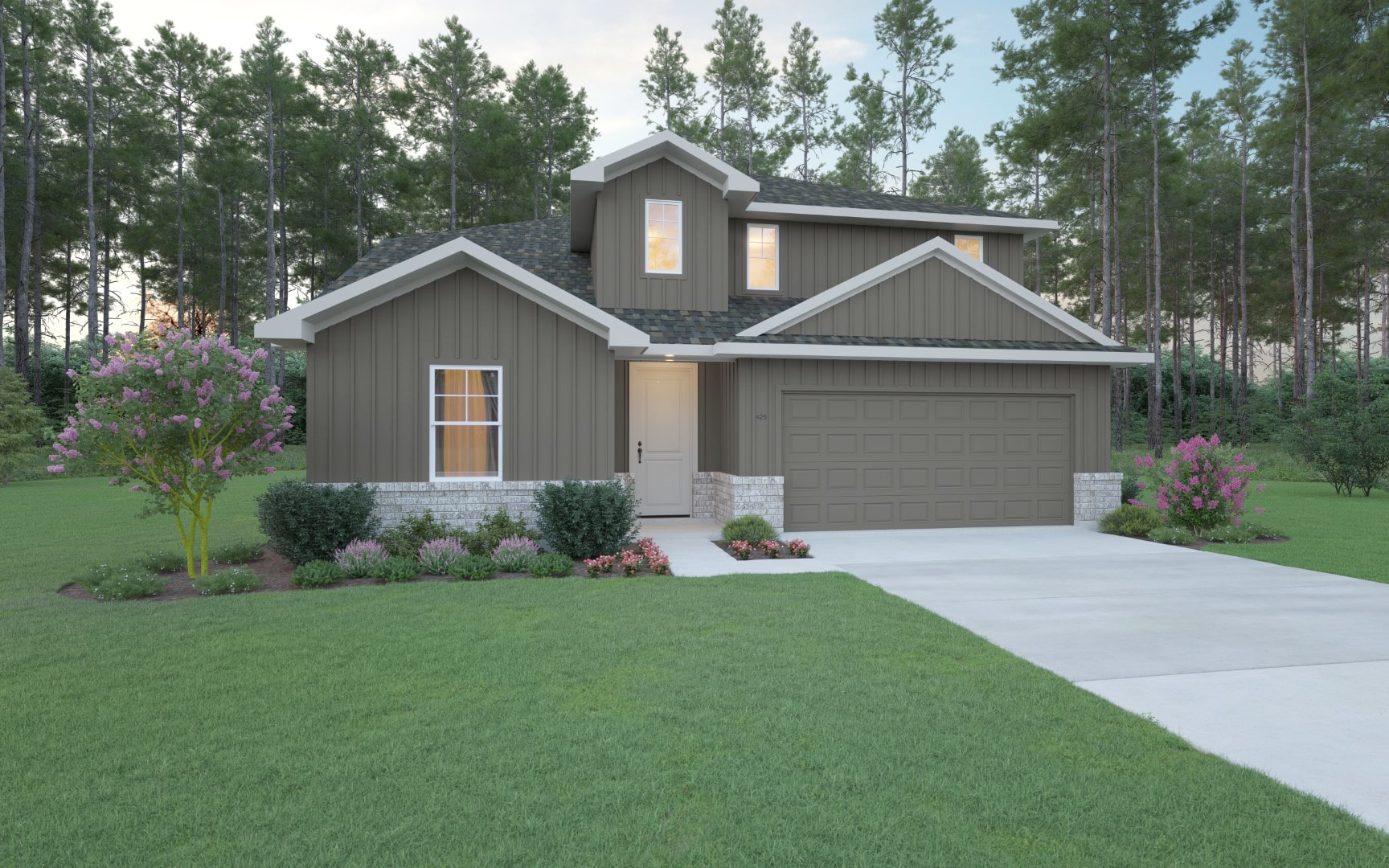 A modern two-story house with brown siding, white trim, and a double garage. The home is surrounded by green lawn, blooming shrubs, and tall pine trees in the background under a partly cloudy sky.