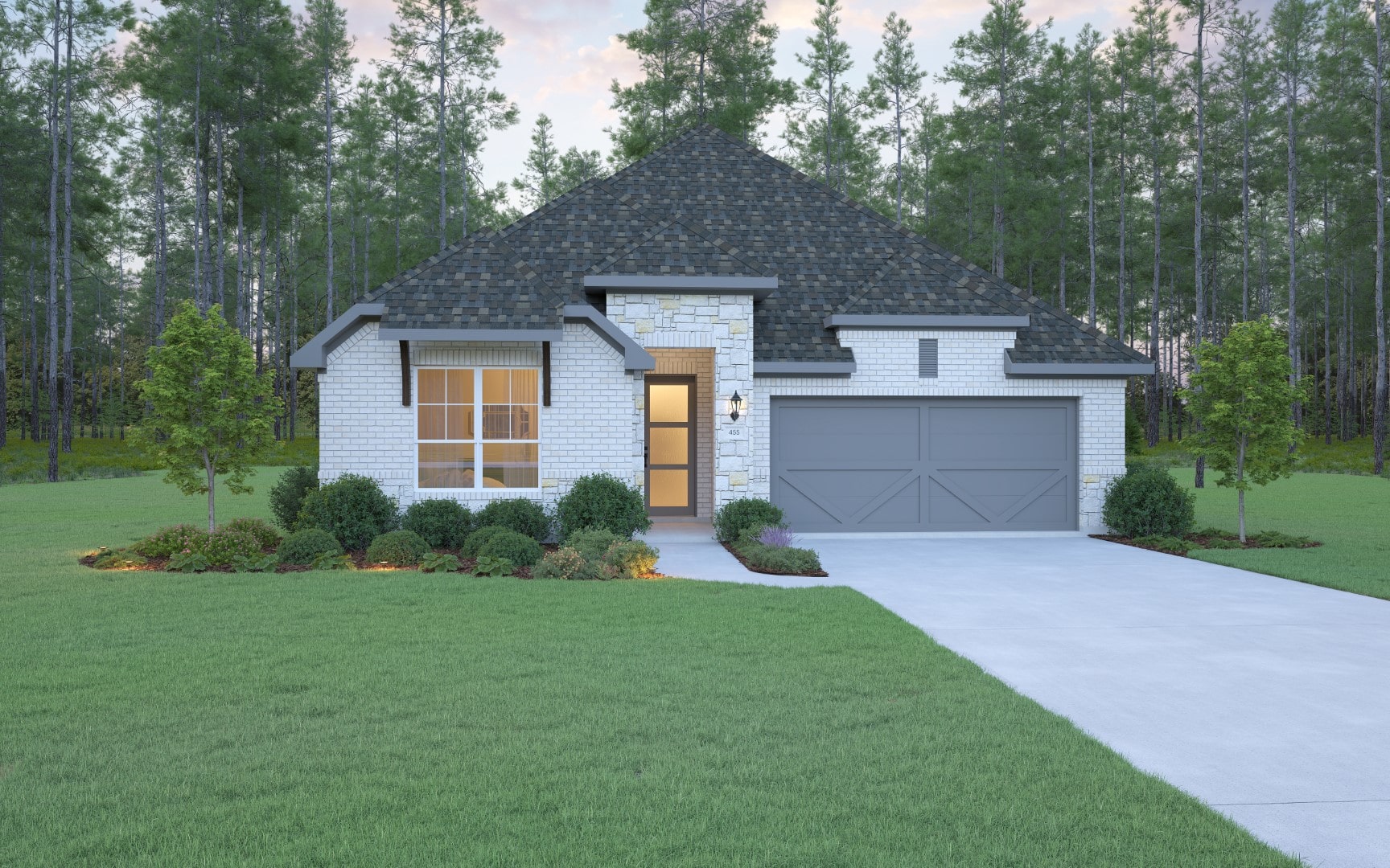 A modern single-story house with a gray shingle roof, white brick and stone exterior, double garage, large front windows, and well-maintained lawn with shrubs and trees, set against a backdrop of tall pine trees.