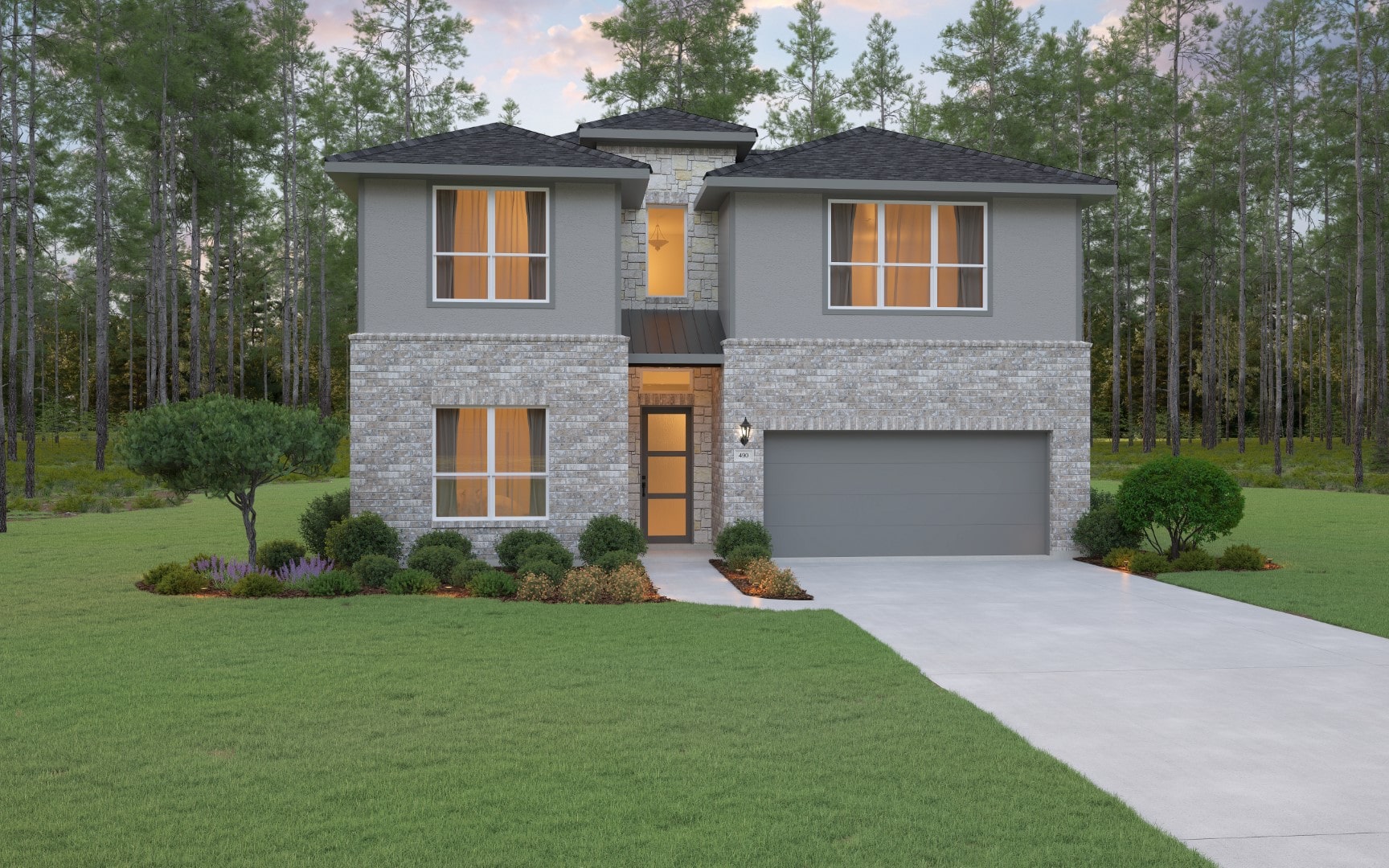 Modern two-story house with gray exterior, brick accents, large windows, and a double garage, surrounded by a manicured lawn, shrubs, and trees in a wooded setting.