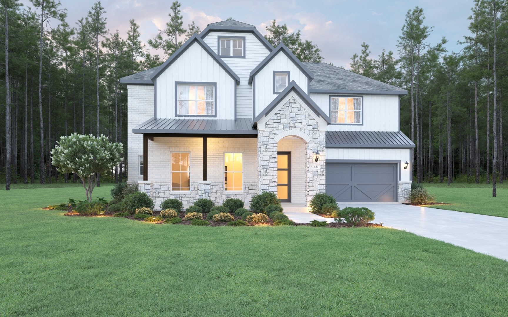 Modern two-story house with a mix of brick and stone exterior, large windows, a double garage, and a well-manicured lawn, surrounded by tall pine trees under a partly cloudy sky.