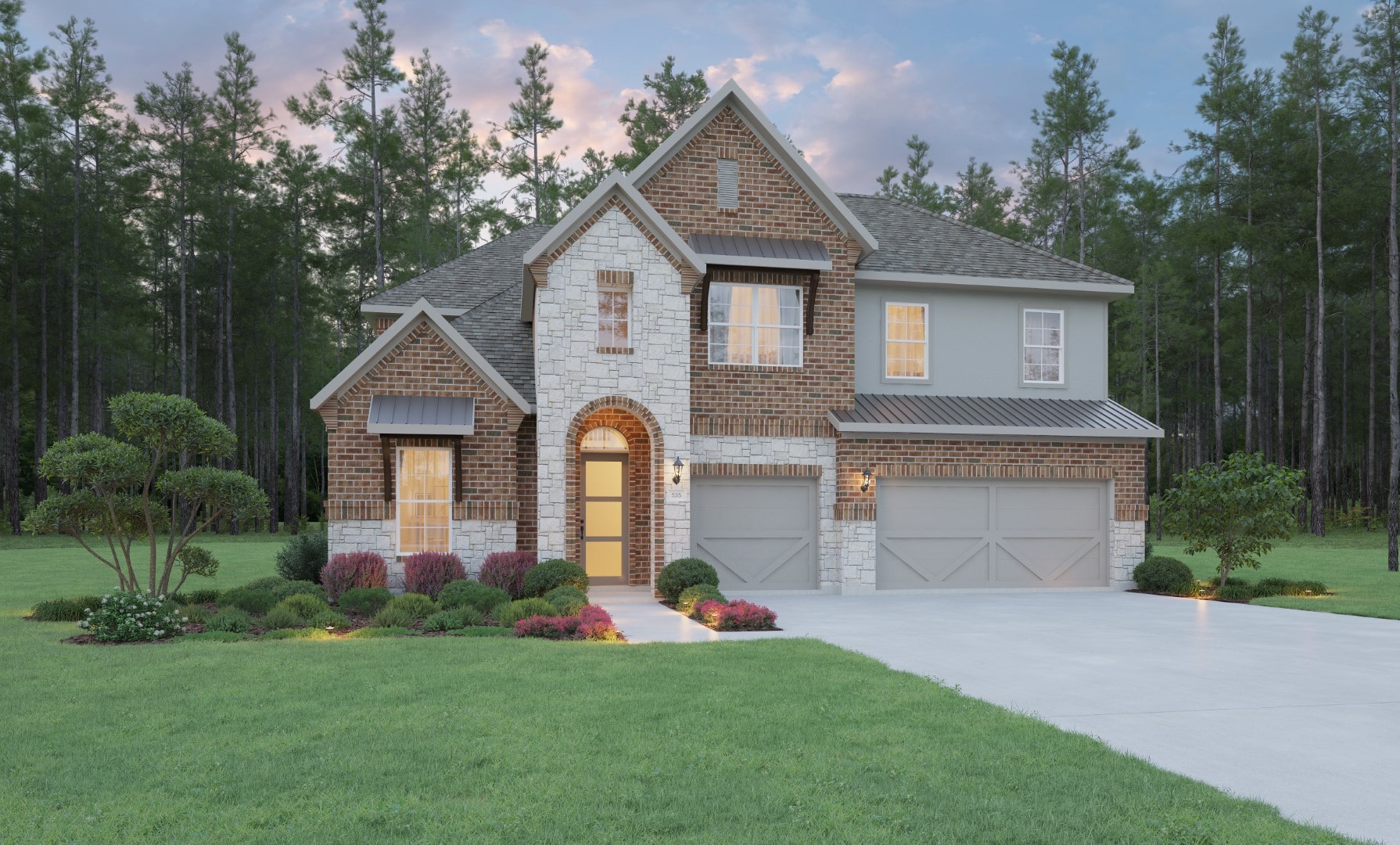 A two-story brick and stone house with a double garage, manicured lawn, shrubs, and tall trees in the background under a partly cloudy sky at dusk.