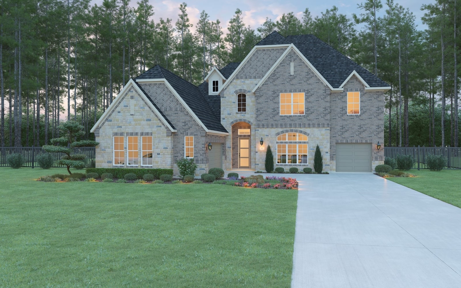 A large, two-story brick house with multiple gables, large windows glowing with light, a single-car garage, and a well-manicured front lawn bordered by trees. A concrete driveway leads to the entrance.