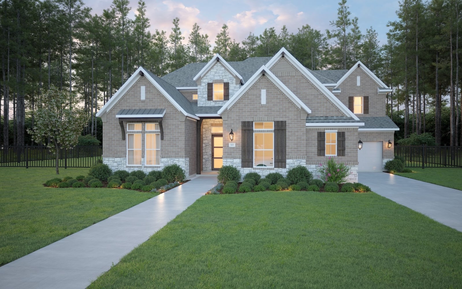 A modern suburban house with brick and stone exterior, large windows, and a manicured lawn. Two concrete walkways lead to the front door, with shrubs and trees surrounding the home. Tall trees line the background.