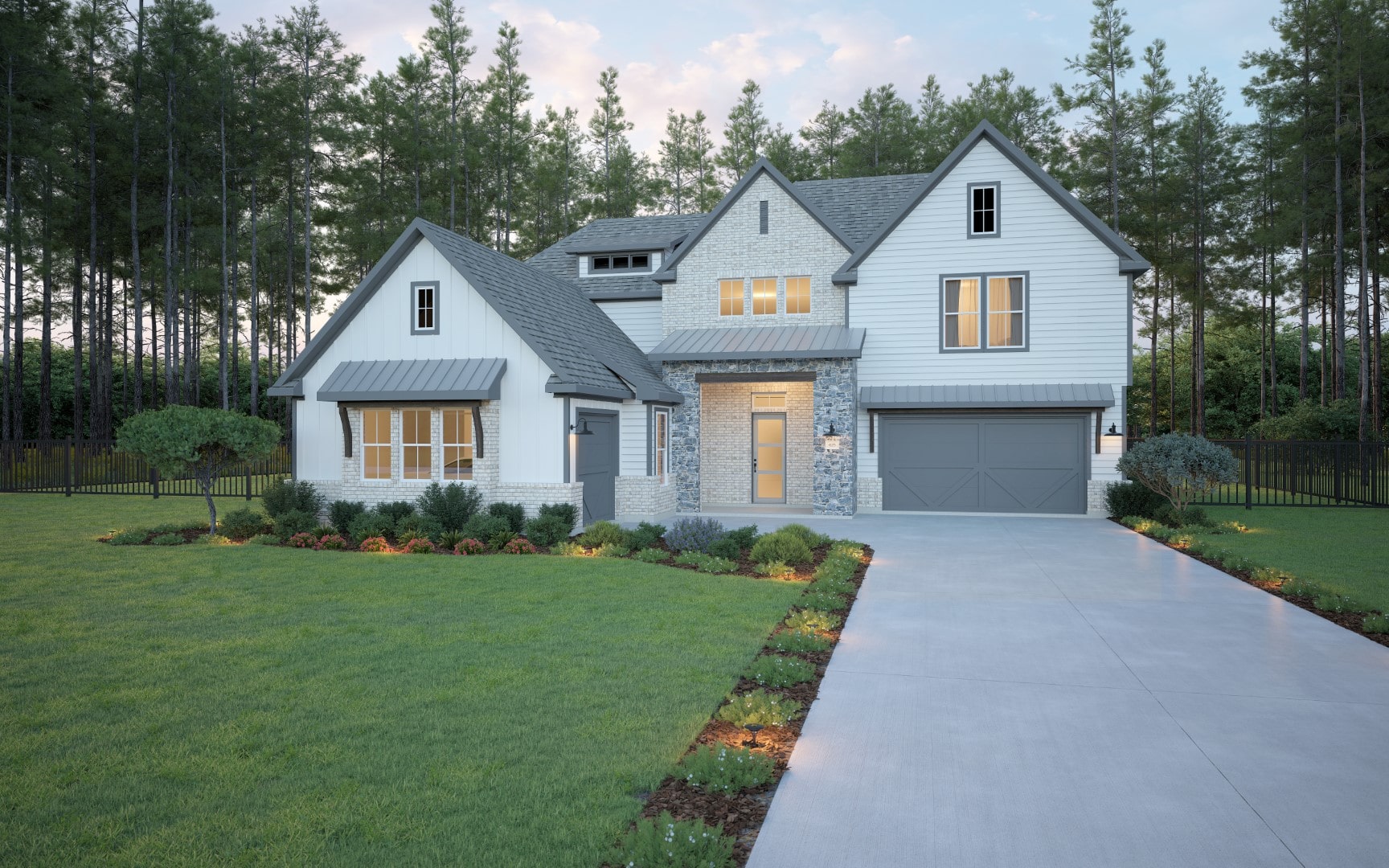 A modern two-story house with white siding, gray roof, and stone accents, sits on a well-manicured lawn with shrubs and a long driveway, surrounded by tall pine trees and a black fence in the background.