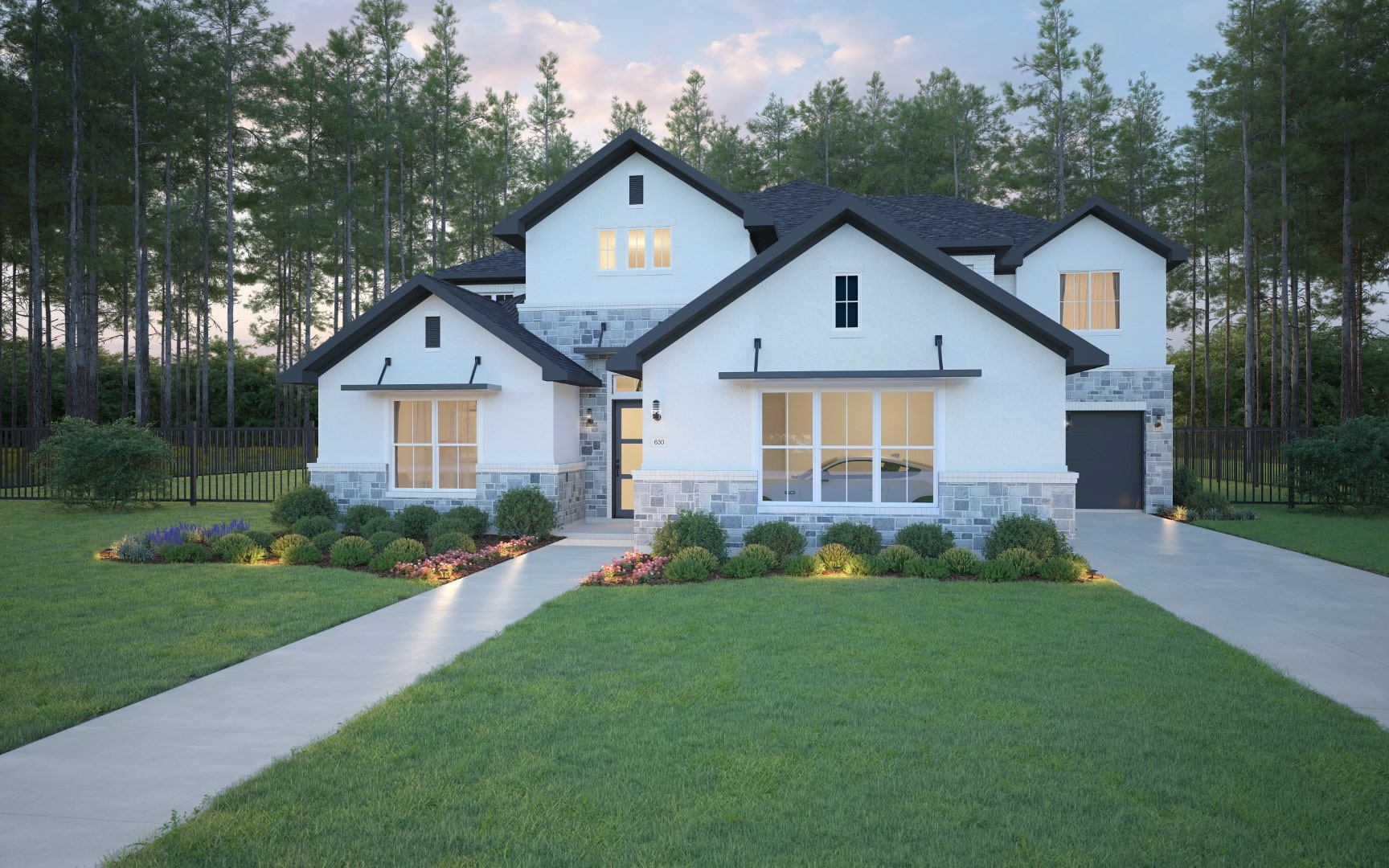 Modern two-story house with white walls, large windows, dark roof, and gray stone accents, surrounded by a well-manicured lawn, landscaped garden, and tall pine trees in the background at dusk.